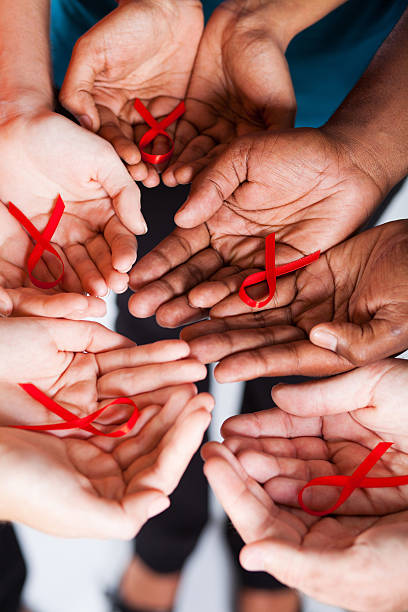 multirazziale persone con nastro rosso per aids/hiv awareness - aids foto e immagini stock