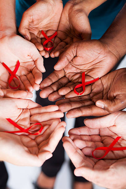 multiracial people holding red ribbon for AIDS HIV awareness group of multiracial people holding red ribbon for AIDS HIV awareness hiv stock pictures, royalty-free photos & images