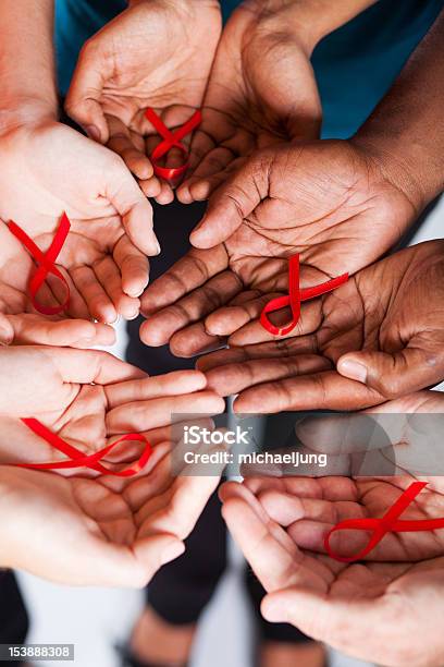 Wielorasowe Ludzie Gospodarstwa Czerwona Wstążka Świadomości Na Aids Hiv - zdjęcia stockowe i więcej obrazów AIDS