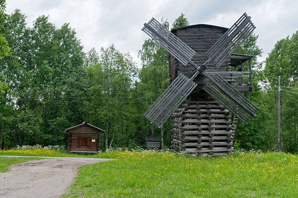 istock Ancient wooden windmill and small cabin against grove background 153892090