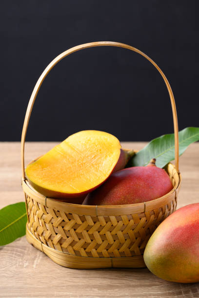 istock Mango fruit (Palmer mango) in basket on wooden background, Tropical fruit 1538925952