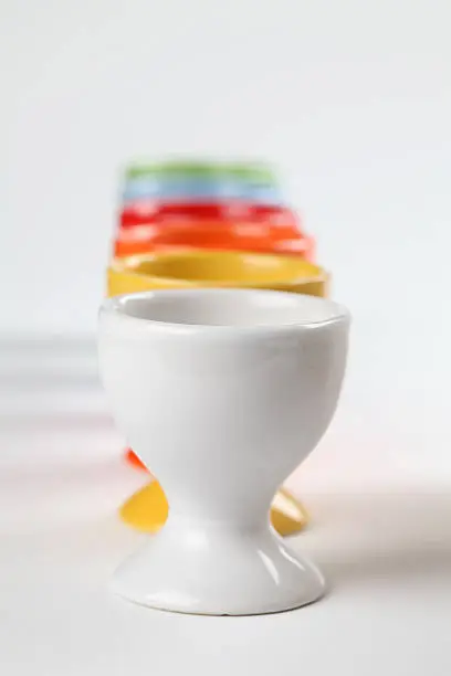 Close-up of a row of colorful eggcups. Shallow dof