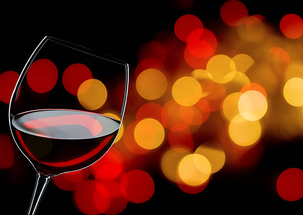 Glass of red wine in front of some blurred lights