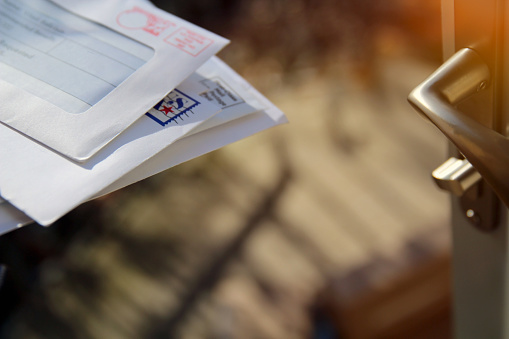 Piles  of letters in a  mail box outside.