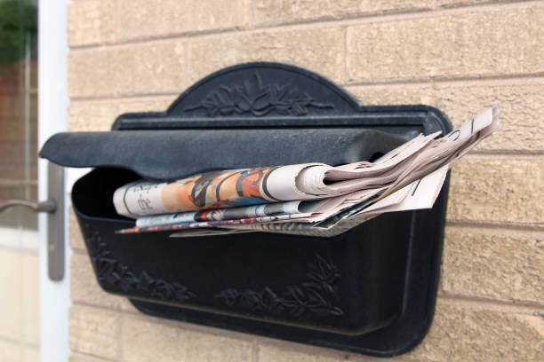 istock Piles  of newspapers in a  mail box outside. 1538971369