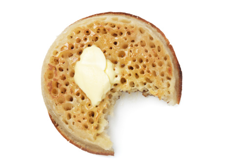 Melting butter on a crumpet isolated on white.