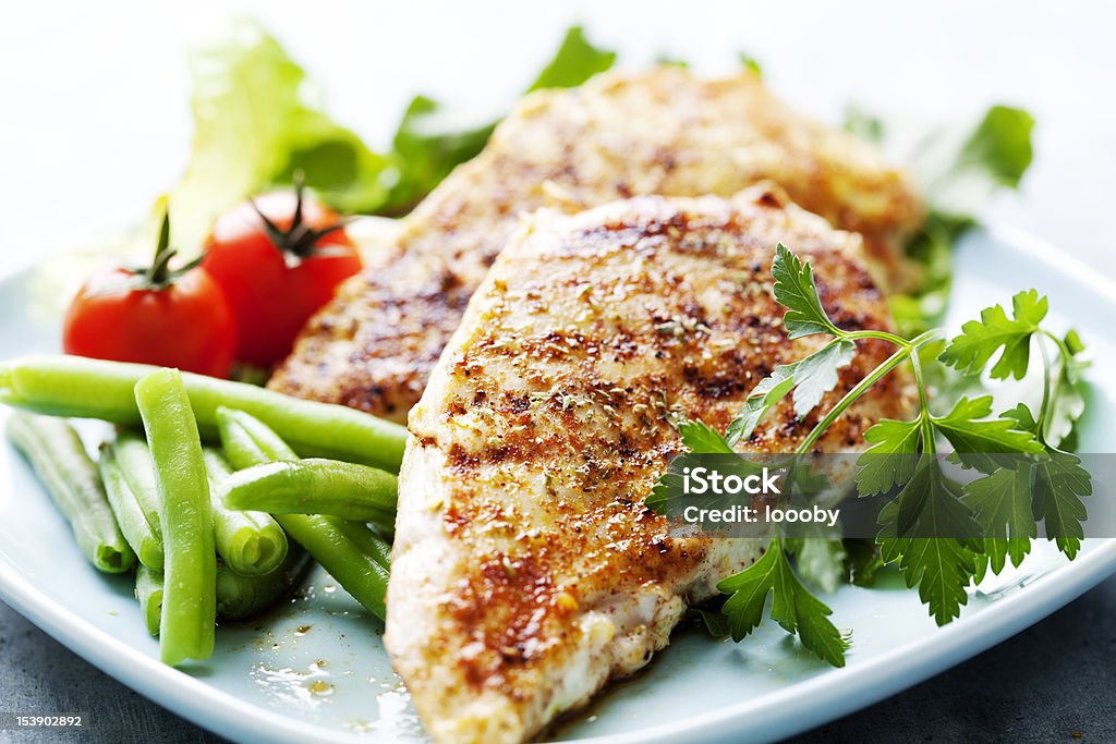 Dinner of grilled chicken breasts, green beans and tomatoes closeup of juicy grilled chicken fillet Chicken Breast Stock Photo