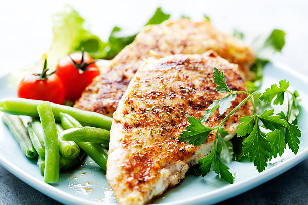Dinner of grilled chicken breasts, green beans and tomatoes closeup of juicy grilled chicken fillet chicken breast photos stock pictures, royalty-free photos & images