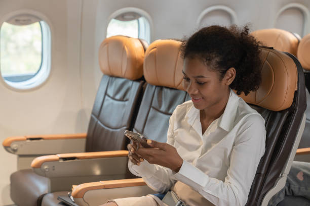 istock Female tourist using mobile phone while sitting on plane. 1539044343
