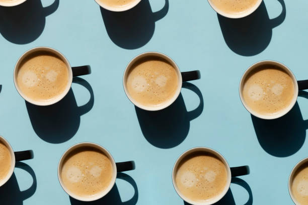 istock Pattern made of cup of cappuccino on blue background 1539052041
