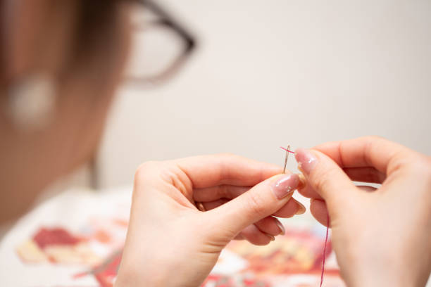 istock A woman wearing glasses threading a needle 1539059049