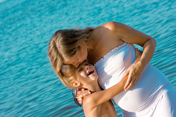 Рregnant madre Besando a la de su hijo - foto de stock