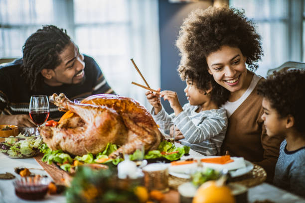 istock Happy black family talking during Thanksgiving meal at dining table. 1539064725