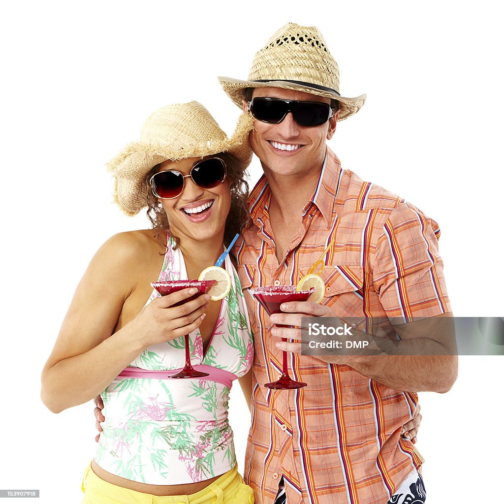 Young Couple on Vacation - Isolated Young couple in summer clothing and straw hats, hold up margaritas. Square shot. Isolated on white. Couple - Relationship Stock Photo