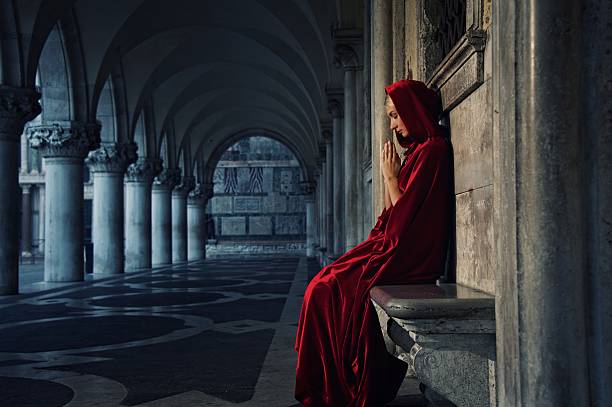 istock Woman in red cloak praying alone 153908955