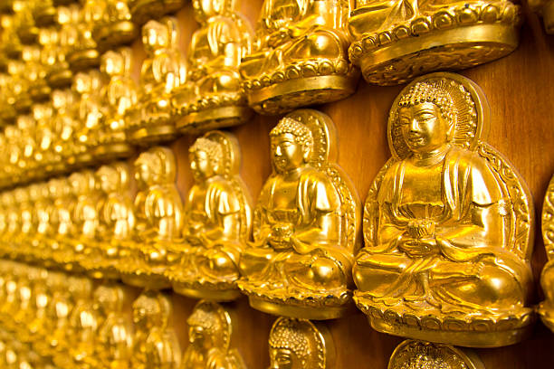 Many small Buddha statue on the wall at chinese temple, Thailand 