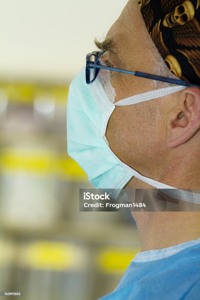 Surgeon's profile Side view of a surgeon wearing a mask and glasses Adult Stock Photo