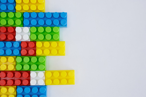 close up of colorful toy constructor blocks over white background with copy space