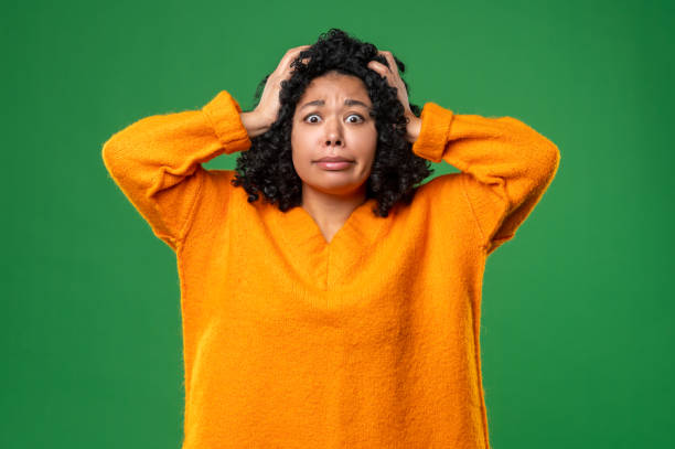 istock Dark-haired woman in orange looking stressed and shocked 1539182600