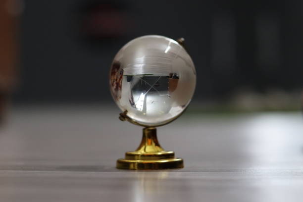 istock Crystal globe with a golden holder in a blurred grey background 1539191591