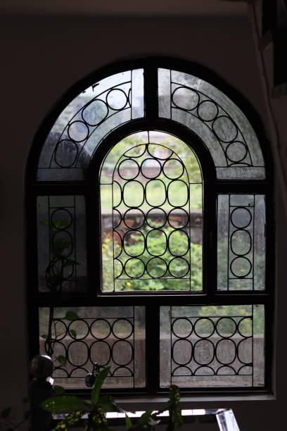 istock Silhouette of An Arched vintage Window with circular Grills 1539192129