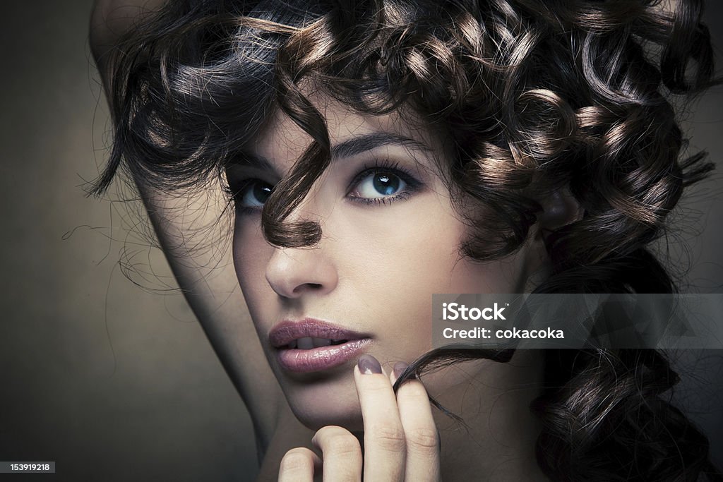 shiny curly hair sensual brunette woman with shiny curly silky hair studio shot Adult Stock Photo