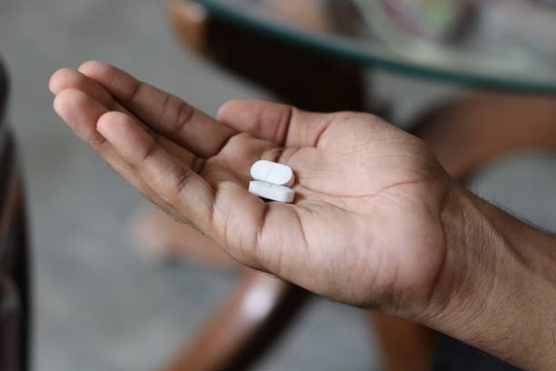 istock A boy Holding two white medical Tablets in hand in bokeh background 1539194801