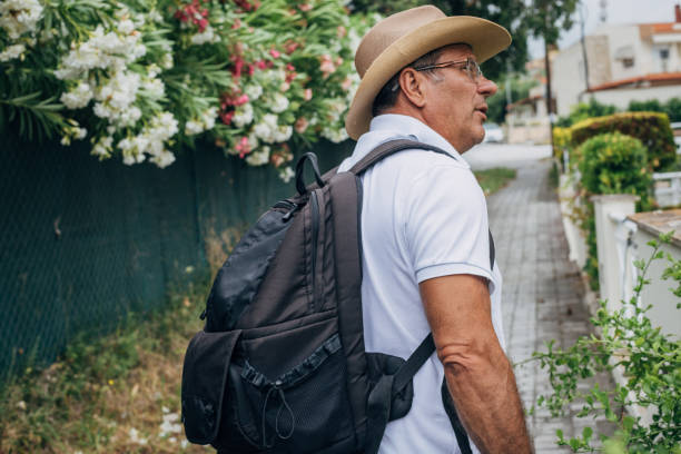 un turista mayor está visitando la ciudad, un nuevo destino - people personal accessory town hat fotografías e imágenes de stock