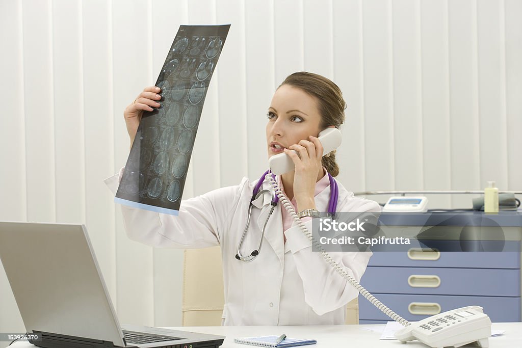 doctor mirando examen de rayos x - Foto de stock de Adulto libre de derechos