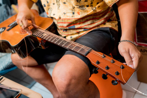 istock Young musician changing strings on a classical guitar in a guitar shop 1539266288