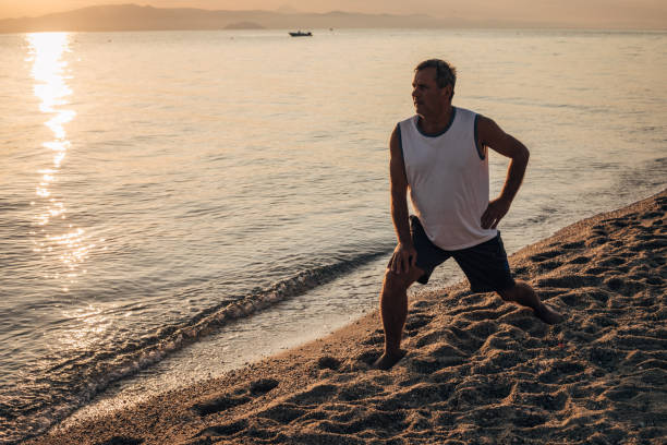 istock An elderly tourist is exercising on the sandy seashore 1539280594