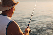 Hobby, a man is fishing with a fishing rod on the seashore