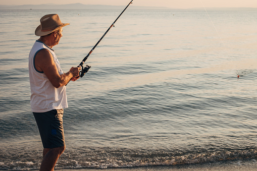 Hobby, a man is fishing with a fishing rod on the seashore