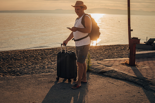 A tourist with a suitcase on the seashore