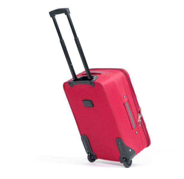 istock Red suitcase on wheels with the handle extended in the running position, isolated on white background. File contains a path to isolation. 1539290007