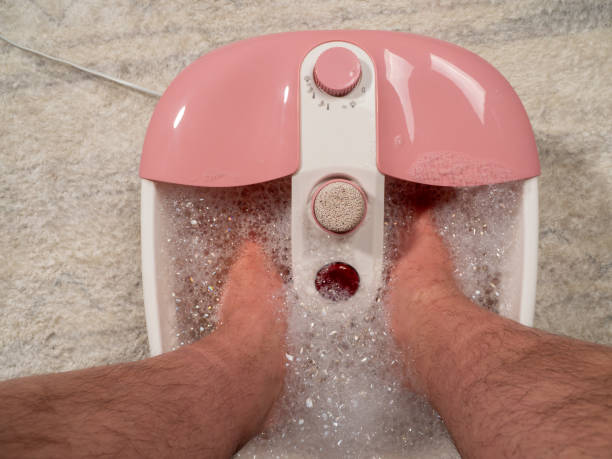 istock Men's legs in a vibrating foot massager. Electromassage foot bath. Relax after work. 1539319997