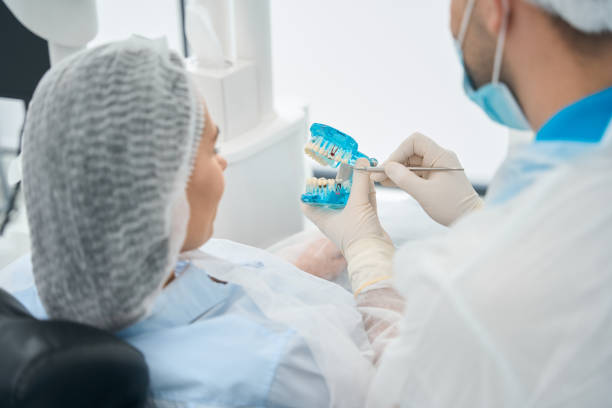 istock Patient examines the model with dental implants 1539337324