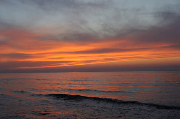 istock Beautiful sunset over ocean in golden hour with clouds and waves 1539344248