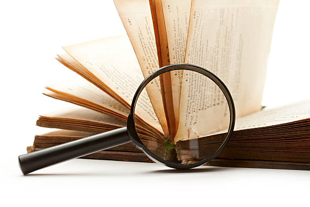 istock Magnifying glass and book isolated on white 153934594
