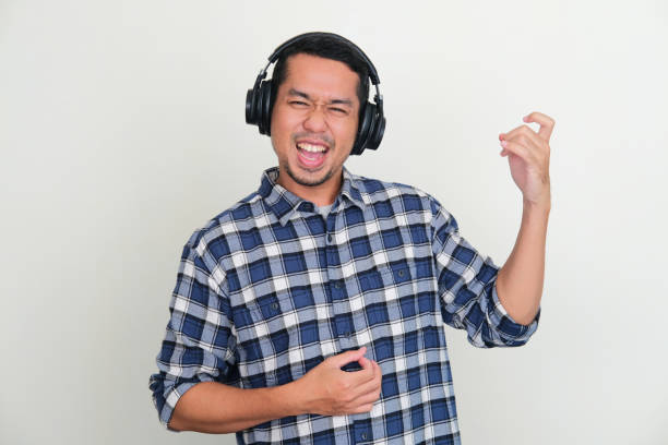 istock A man wearing headphone showing happy expression while pretending playing guitar 1539350563