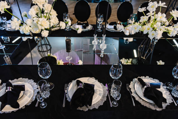 istock Serving, setting table. Plate and glass, stack, wineglass, luxury black rich decor. Wedding set up, dinner table reception. Birthday, baptism, event. Closeup details interior. Top view. 1539379516