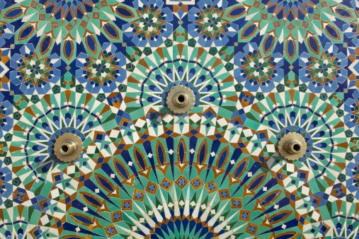 Colorful mosaic tiled pattern and three brass spouts on the external walls of the King Hassan II Mosque, Casablanca