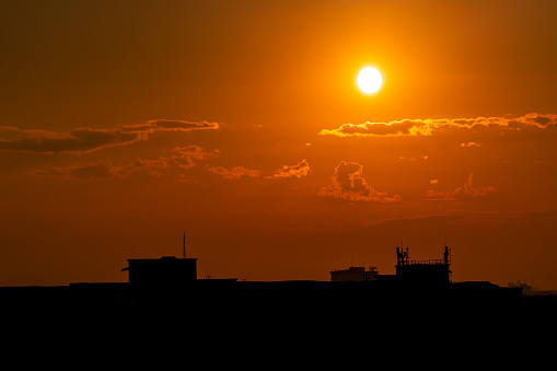 Sunset over the city. Silhouette buildings. Summer urban. Global warming concept.