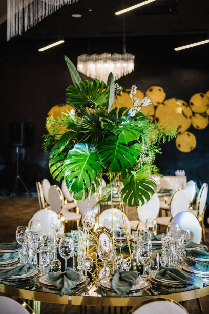 istock Banquet decoration composition flower greenery in hall restaurant. Luxury wedding reception. Table setting, setup. Trendy decor for birthday party. Golden geometric chairs. Round served table guests. 1539436711