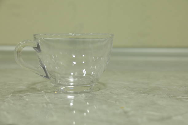 Empty glass cup on a table in the kitchen. Shallow depth of field