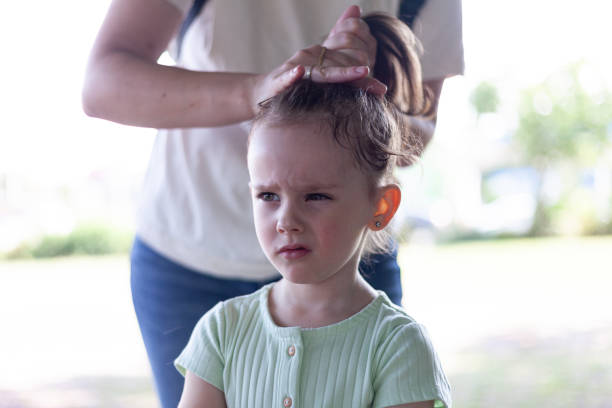 istock Mother combing her daughter's hair in the park. Selective focus. 1539484918