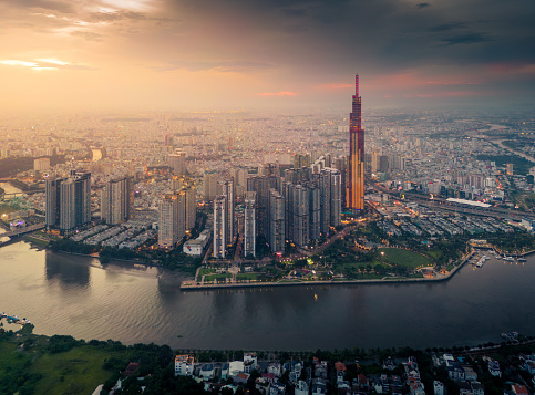 Aerial view of a Ho Chi Minh City, Vietnam with development buildings, transportation, energy power infrastructure. Financial and business centers. Sunset to night. Travel and landscape concept.