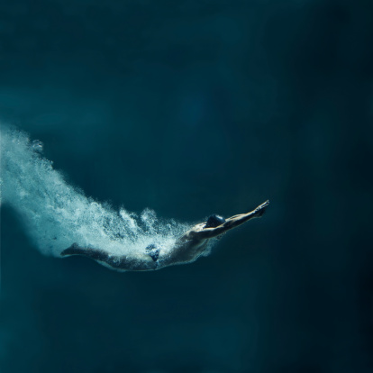 Nadador buceo después del salto, Vista submarina photo