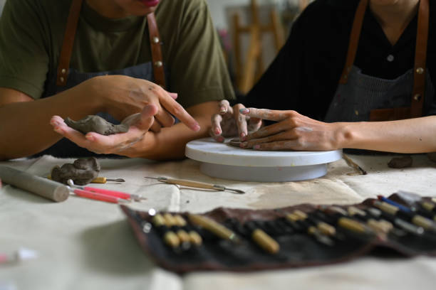 istock Cropped image of master ceramist teaches helping student creating plate handmade from clay in art workshop. 1539496220