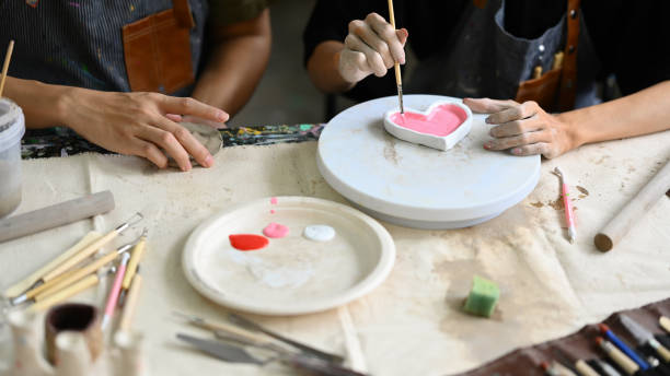istock Two young creative man painting, decorating handmade dishes in workshop. Handicraft, creativity and hobby concept. 1539496424